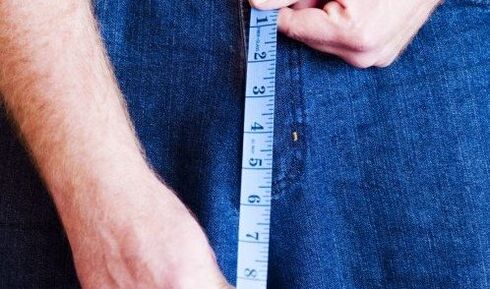 The man measures the length of the penis